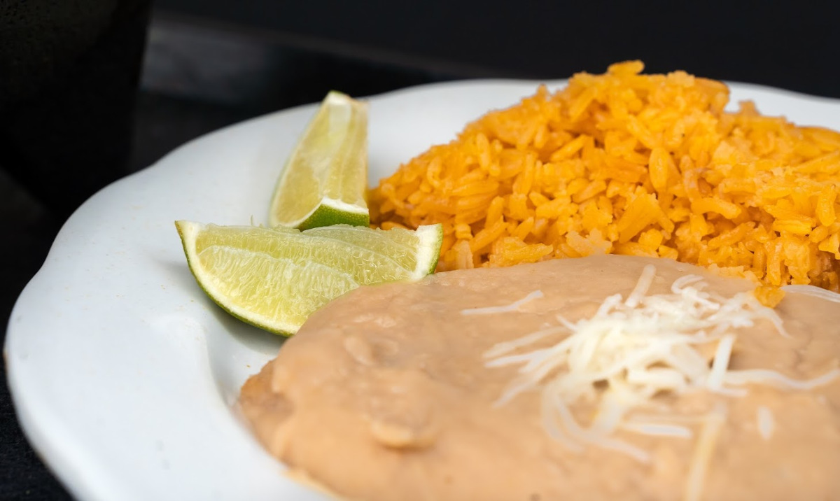 Side of rice, refried beans and lime wedges